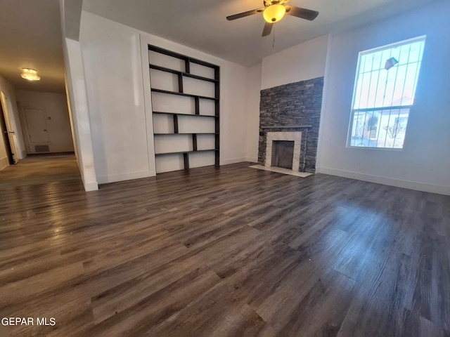 unfurnished living room with dark hardwood / wood-style floors, ceiling fan, and a fireplace