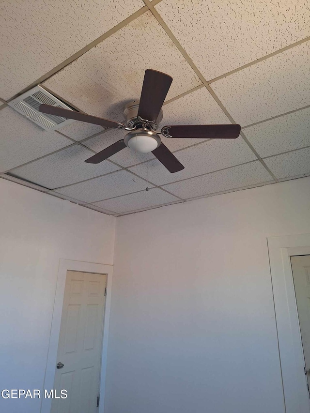 details featuring ceiling fan and a drop ceiling