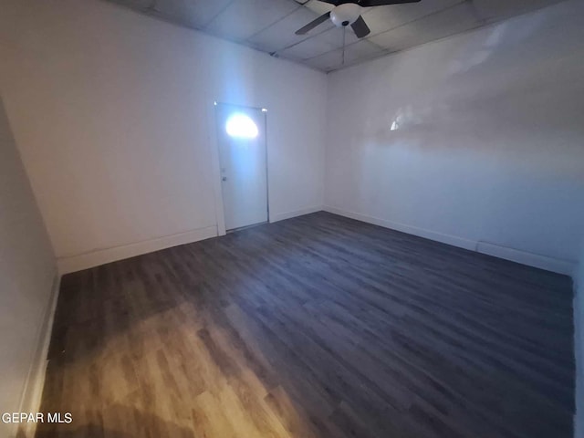 empty room with ceiling fan and dark hardwood / wood-style flooring