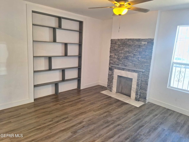 unfurnished living room featuring dark hardwood / wood-style flooring, ceiling fan, and a fireplace