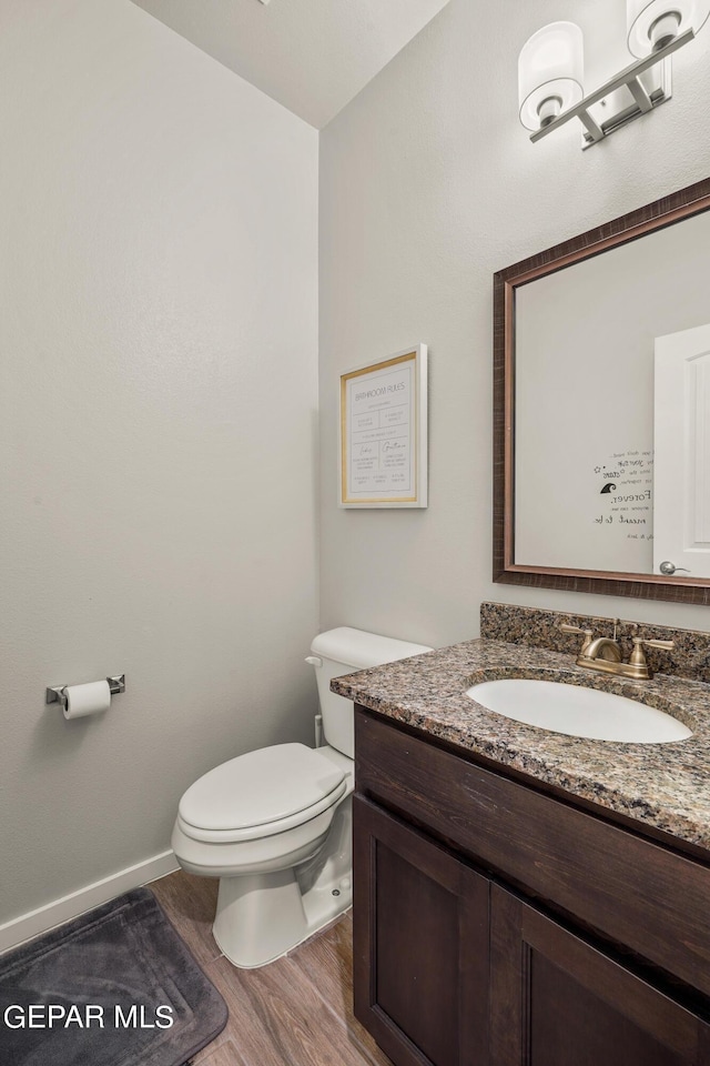 bathroom with vanity, wood-type flooring, and toilet