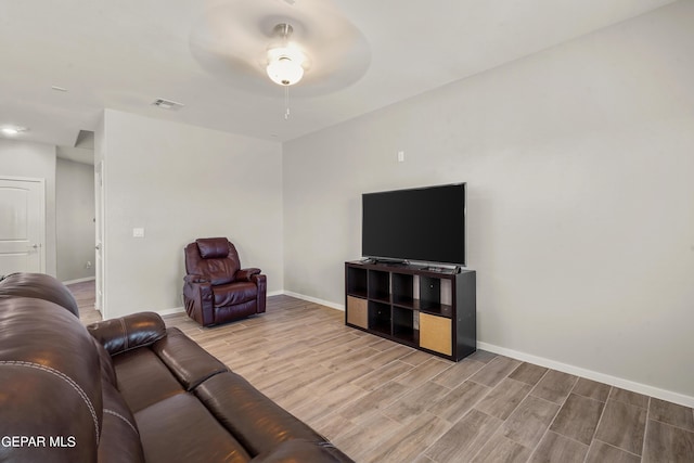 living room featuring ceiling fan and light hardwood / wood-style floors