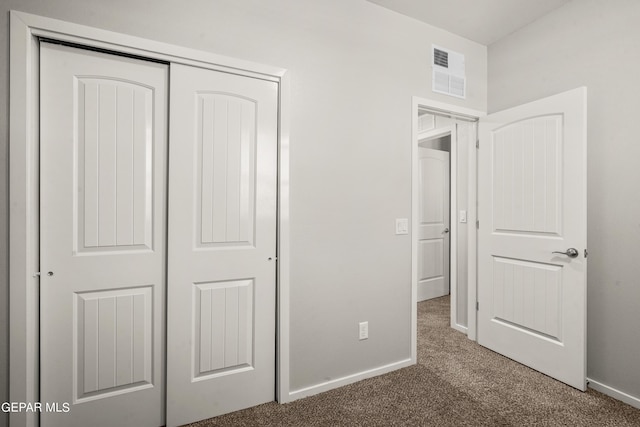 unfurnished bedroom with a closet and dark carpet