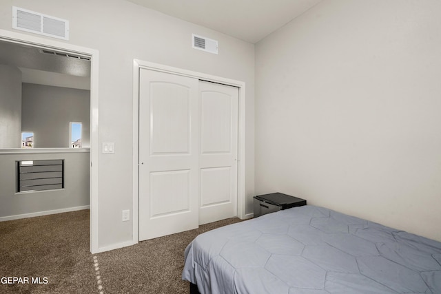 bedroom with dark colored carpet and a closet