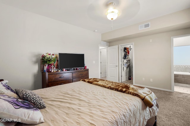 carpeted bedroom with a closet, ensuite bath, and ceiling fan