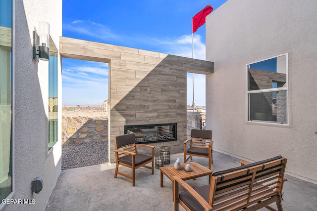 view of terrace featuring an outdoor living space with a fireplace