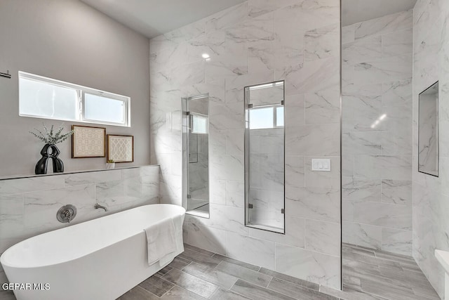 bathroom featuring tile floors, shower with separate bathtub, and tile walls