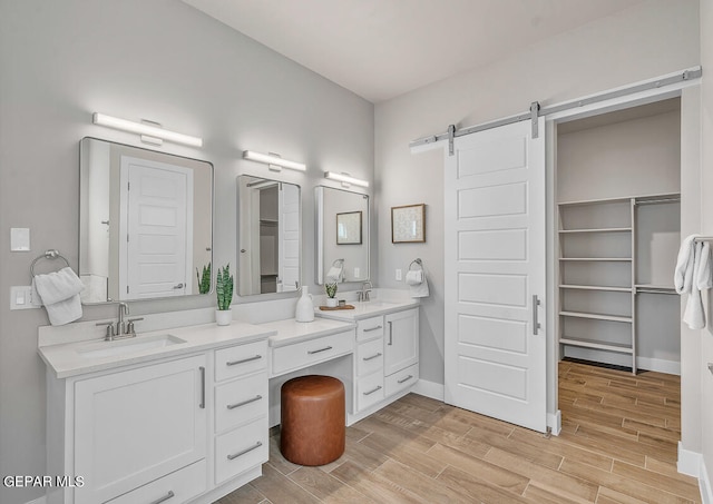 bathroom featuring oversized vanity, dual sinks, and hardwood / wood-style flooring