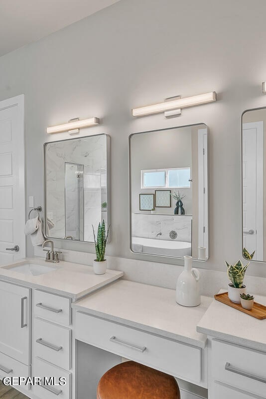 bathroom featuring a bath to relax in and oversized vanity