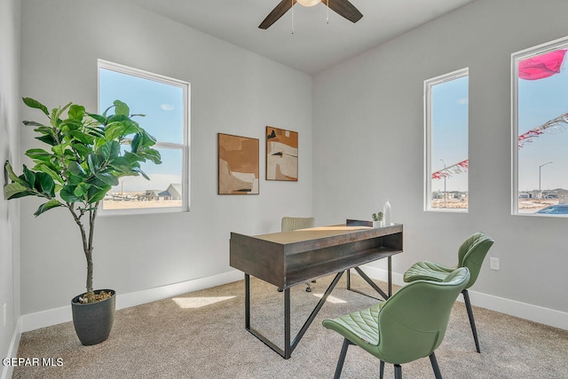 office space with plenty of natural light, ceiling fan, and carpet floors