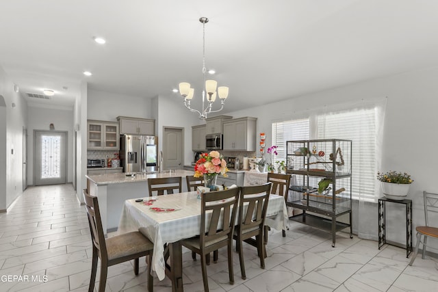 dining room with a wealth of natural light, a notable chandelier, and sink