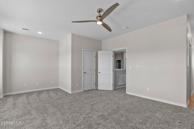 unfurnished bedroom with ceiling fan and light colored carpet