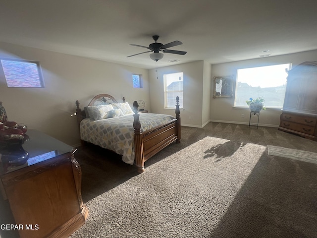 carpeted bedroom featuring ceiling fan and multiple windows