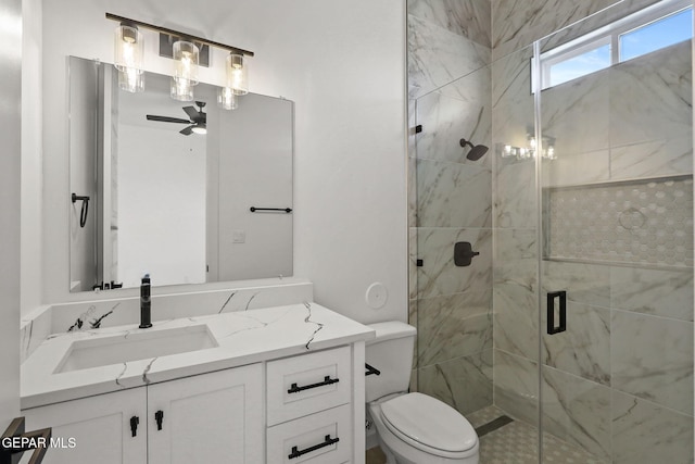 bathroom featuring vanity, toilet, ceiling fan, and a shower with door