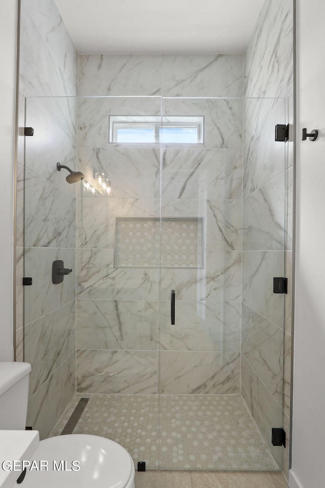 bathroom with a shower with door, tile patterned floors, and toilet