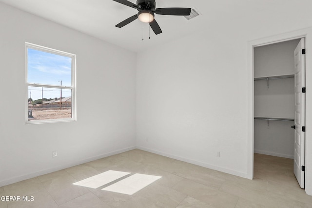 unfurnished bedroom featuring a spacious closet, a closet, ceiling fan, and light tile patterned flooring