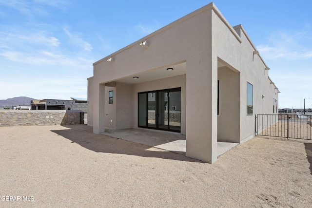 back of property with a patio and a mountain view