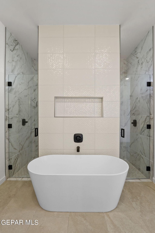 bathroom featuring tile walls, tile patterned floors, and separate shower and tub