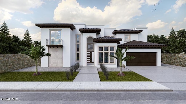 mediterranean / spanish home with an attached garage, a balcony, driveway, a tiled roof, and stucco siding