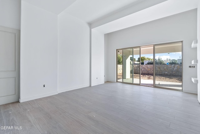 empty room featuring baseboards and wood finished floors