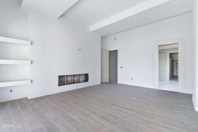 unfurnished living room with a fireplace, visible vents, and wood finished floors