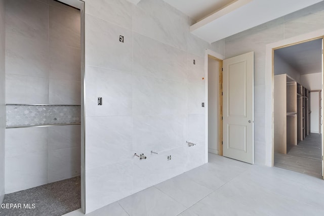 bathroom featuring tile patterned flooring and tile walls