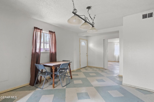 dining room with a textured ceiling and tile flooring