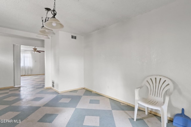 tiled spare room with ceiling fan and a textured ceiling