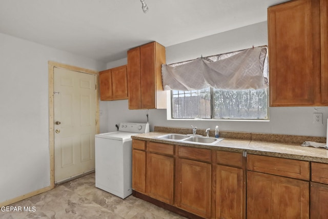 clothes washing area featuring sink, light tile flooring, cabinets, and washer / clothes dryer