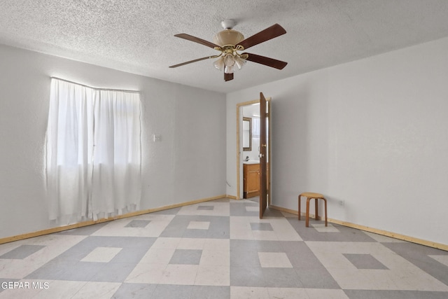 empty room featuring a textured ceiling, ceiling fan, and light tile flooring