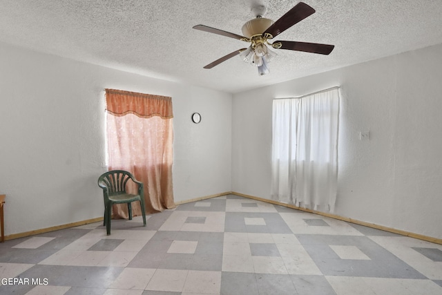 empty room featuring plenty of natural light, ceiling fan, and light tile flooring