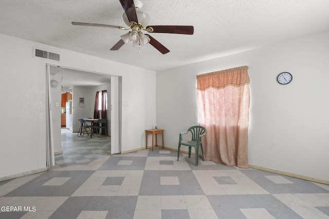 unfurnished room with tile flooring, plenty of natural light, ceiling fan, and a textured ceiling