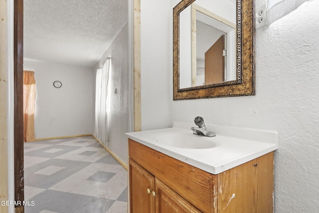 bathroom featuring tile flooring, vanity, and a textured ceiling