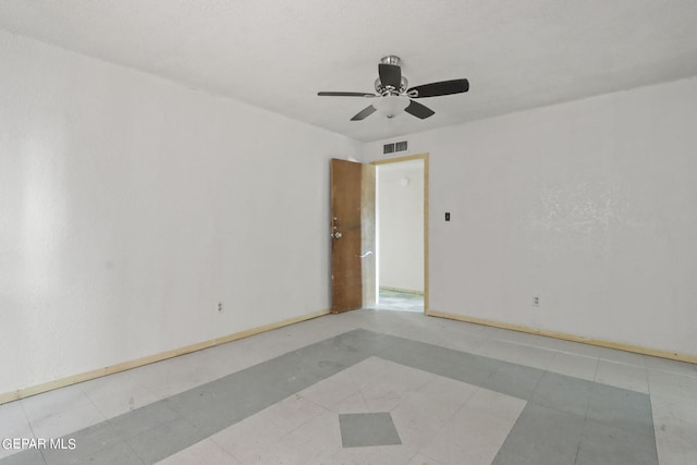 tiled spare room with ceiling fan