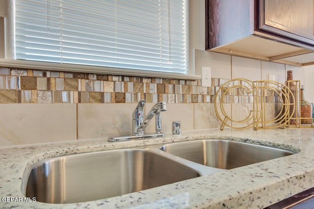 details featuring light stone counters and sink