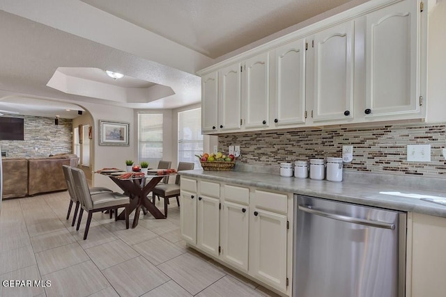 kitchen featuring dishwasher, decorative backsplash, and white cabinets