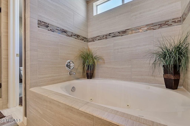 bathroom with toilet and tiled tub