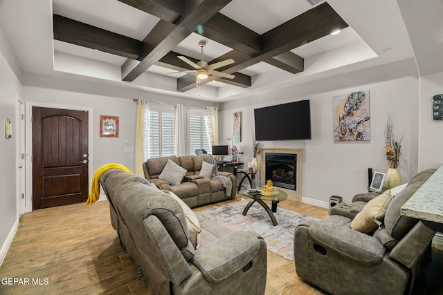 living room with ceiling fan, beam ceiling, light wood-type flooring, and coffered ceiling