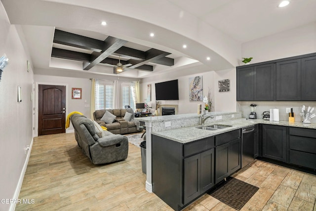 kitchen with kitchen peninsula, light stone counters, ceiling fan, sink, and black dishwasher