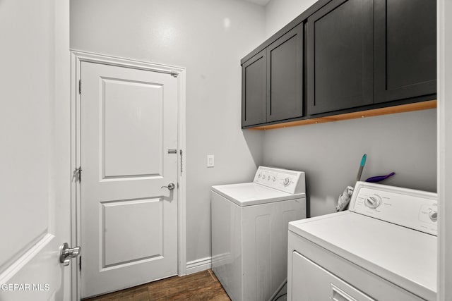 laundry room with cabinets, dark wood-type flooring, and washing machine and clothes dryer