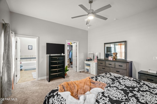 carpeted bedroom with ceiling fan, a spacious closet, and connected bathroom