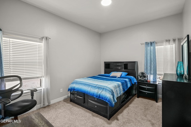 bedroom with light colored carpet and multiple windows