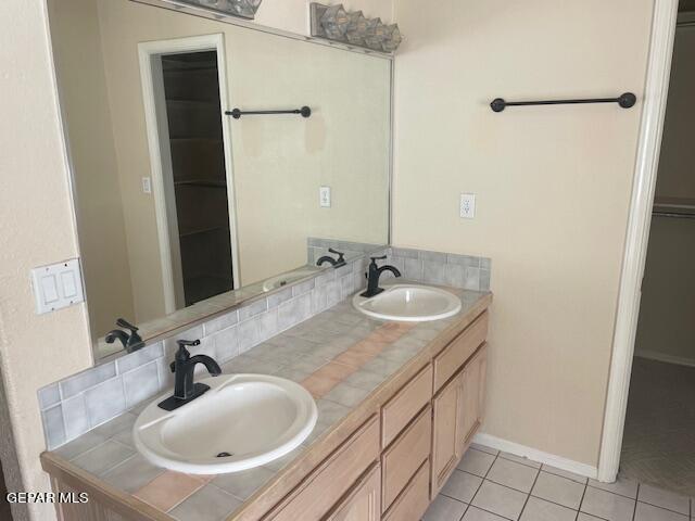 bathroom featuring tile patterned flooring, vanity, and backsplash