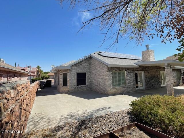 back of house featuring solar panels and a patio