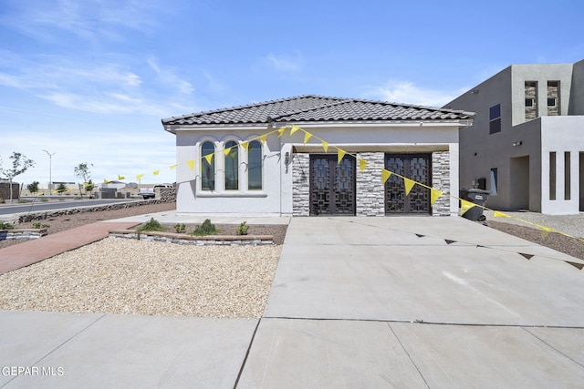 265 Adamtowne Dr, El Paso, TX 79928 - view of front of house featuring stone siding, stucco siding, a tile roof, and french doors