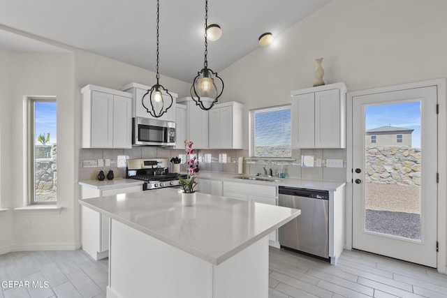265 Adamtowne Dr, El Paso, TX 79928 - kitchen with stainless steel appliances, backsplash, vaulted ceiling, light countertops, and white cabinets