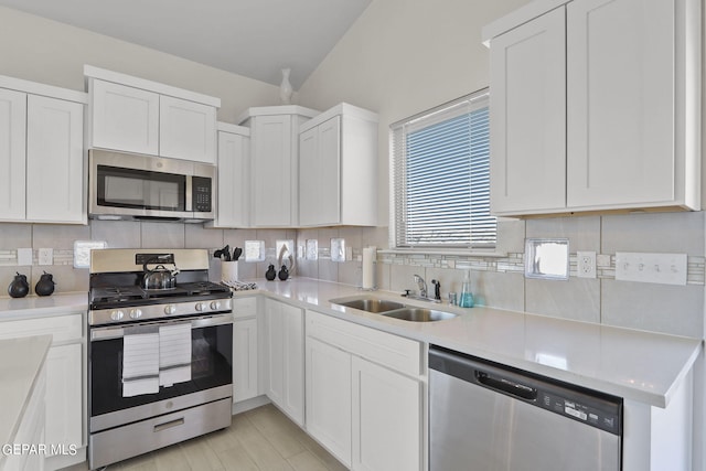 kitchen with white cabinets, stainless steel appliances, tasteful backsplash, and sink