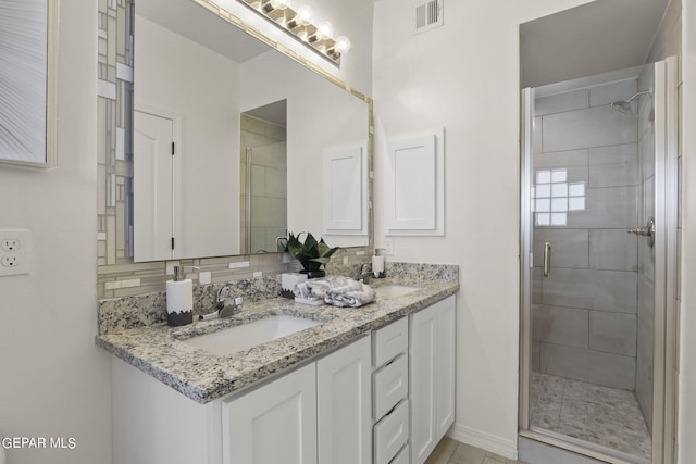265 Adamtowne Dr, El Paso, TX 79928 - bathroom featuring a shower stall, double vanity, and baseboards