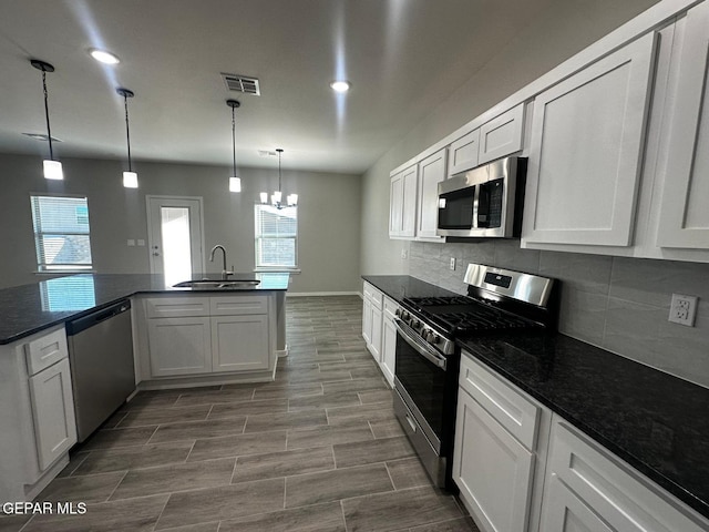 kitchen with stainless steel appliances, plenty of natural light, sink, and white cabinetry