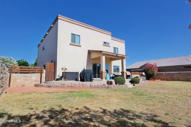 back of house featuring a patio and a lawn